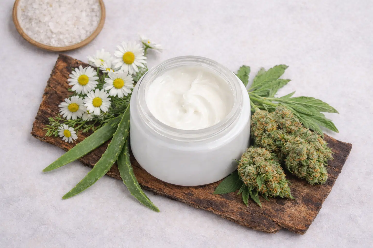 Crema viso in barattolo su tronco, con camomilla, foglie di aloe e cime di cannabis