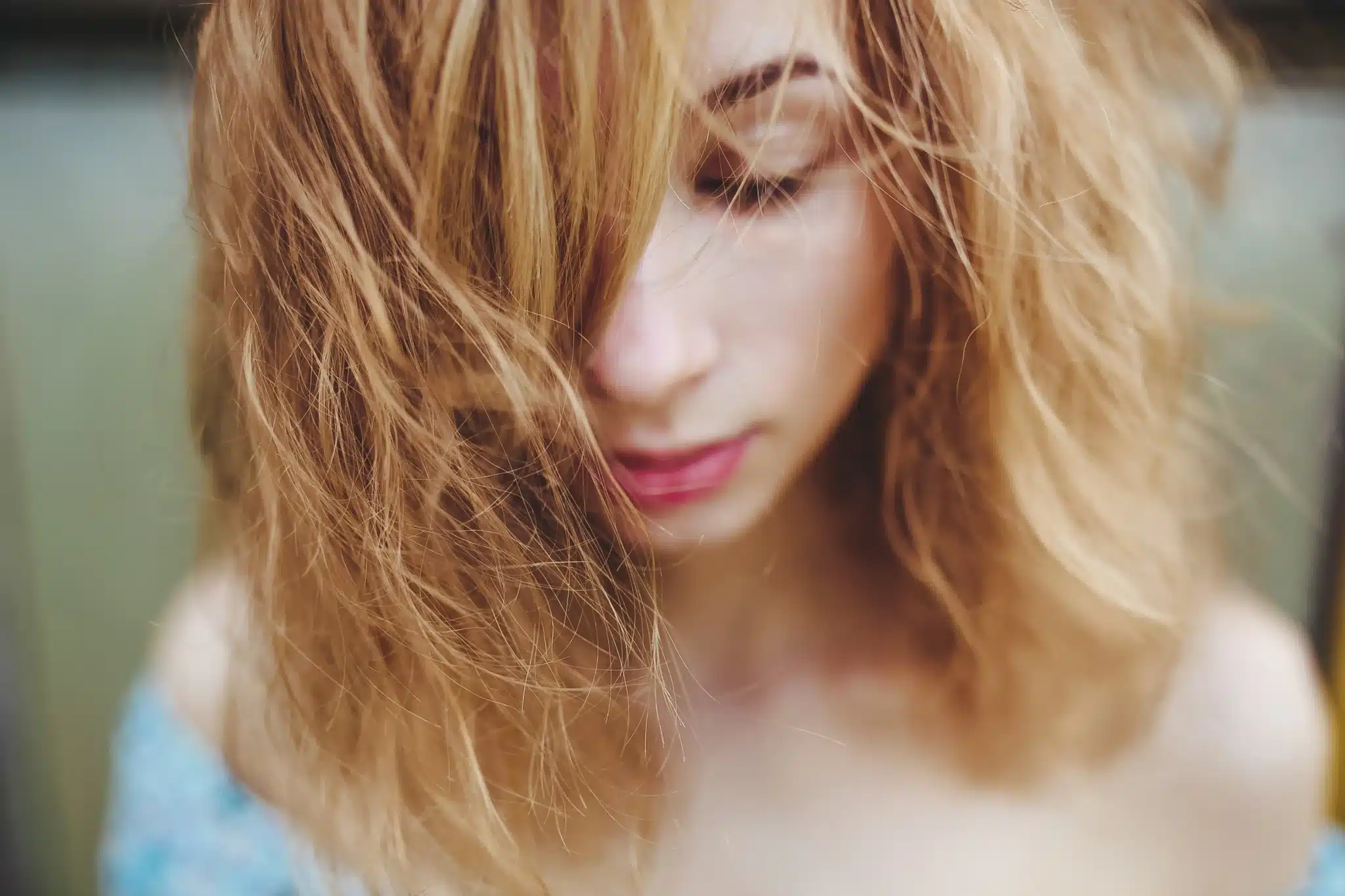 primo piano ragazza dai capelli biondi secchi e  sfibrati 